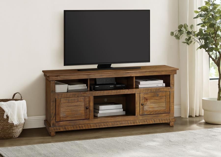 Wooden TV stand with TV, books, and electronics in a living room.