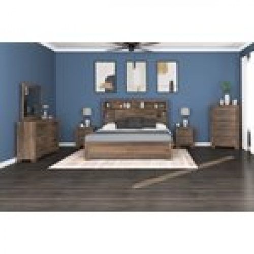 Bedroom with wooden furniture set: bed, dresser, nightstands, and chest. Blue walls and three framed pictures.