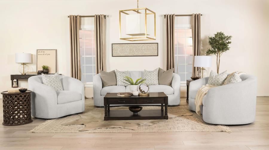 Living room with light-colored sofa, chairs, dark coffee table, and gold light fixture. Beige walls, curtains, and rug.