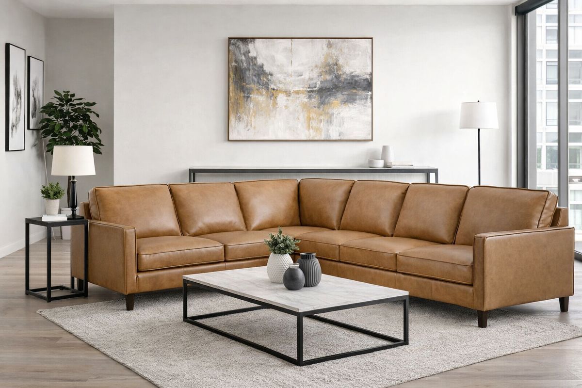 Living room with a tan leather sectional sofa, marble coffee table, artwork, and a rug.
