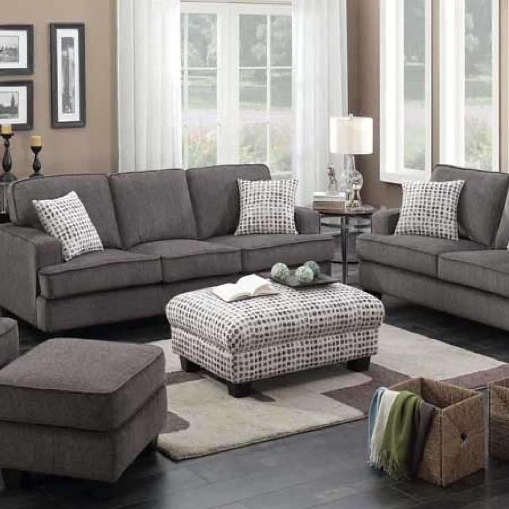 Gray living room set with sofa, loveseat, ottoman, and decor.