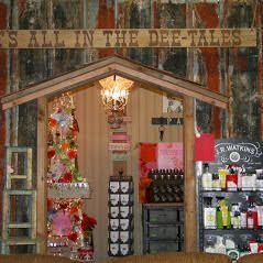 Shop display with shelf, shed-like structure, products, sign, and chandelier.