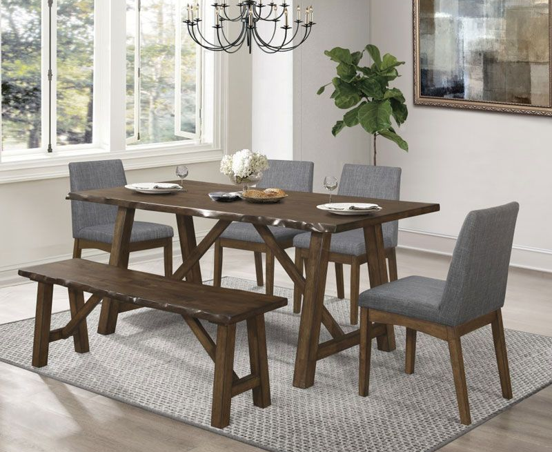 Dining table set with bench and chairs on a rug in a bright room.