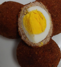 A plate of food with a hard boiled egg in the middle