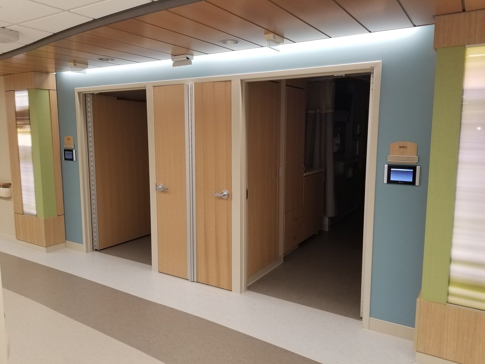 A hallway with wooden doors and a blue wall