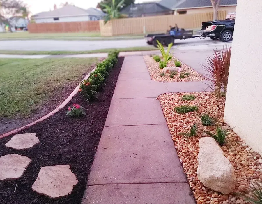 Front walkway with landscaped garden beds, stepping stones, and a quiet street in the background
