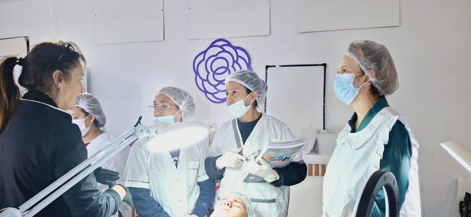 Personas recibiendo tratamientos faciales en un salón luminoso, con varios técnicos trabajando alrededor de las camillas de tratamiento.