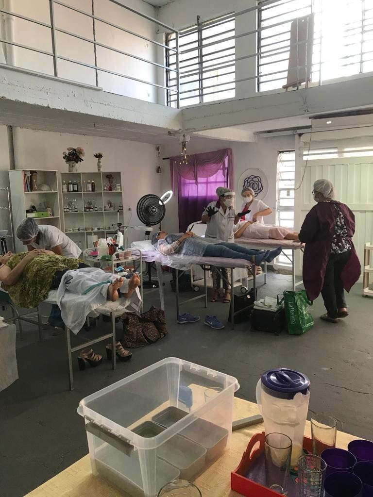 Sala de hospital con varios pacientes y cuidadores alrededor de las camas en una habitación luminosa y ventilada.