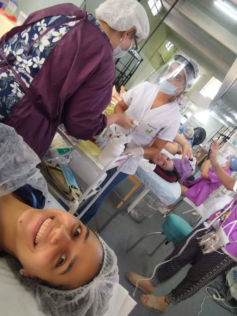 Personal sanitario atiende a pacientes en un concurrido pasillo de hospital, con un niño enmascarado en primer plano.