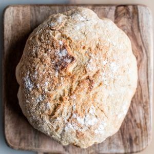 Round rustic loaf of bread on a wooden cutting board