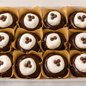 Tray of chocolate cupcakes topped with white frosting and three chocolate chips each