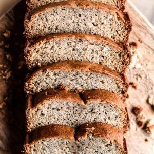 Sliced loaf of seeded bread on a wooden surface, close-up view