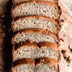 Sliced loaf of seeded bread on a wooden surface, close-up view