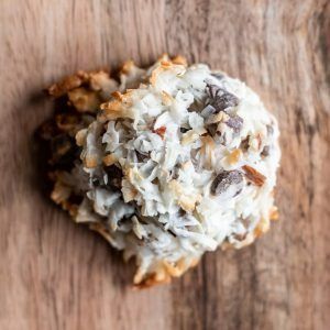 White frosted cookie topped with nuts on a wooden surface