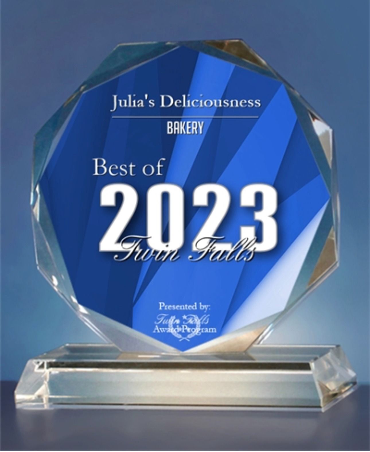Blue faceted award plaque reading “Best of 2023” on a clear base against a blue background