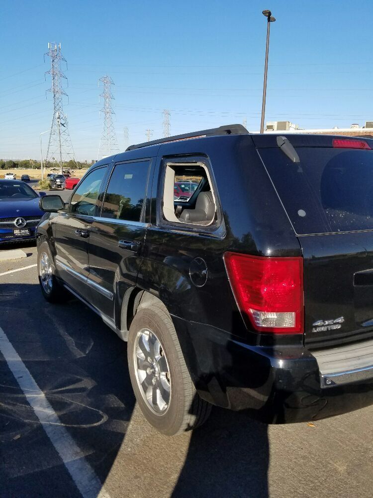 A black jeep grand cherokee is parked in a parking lot.