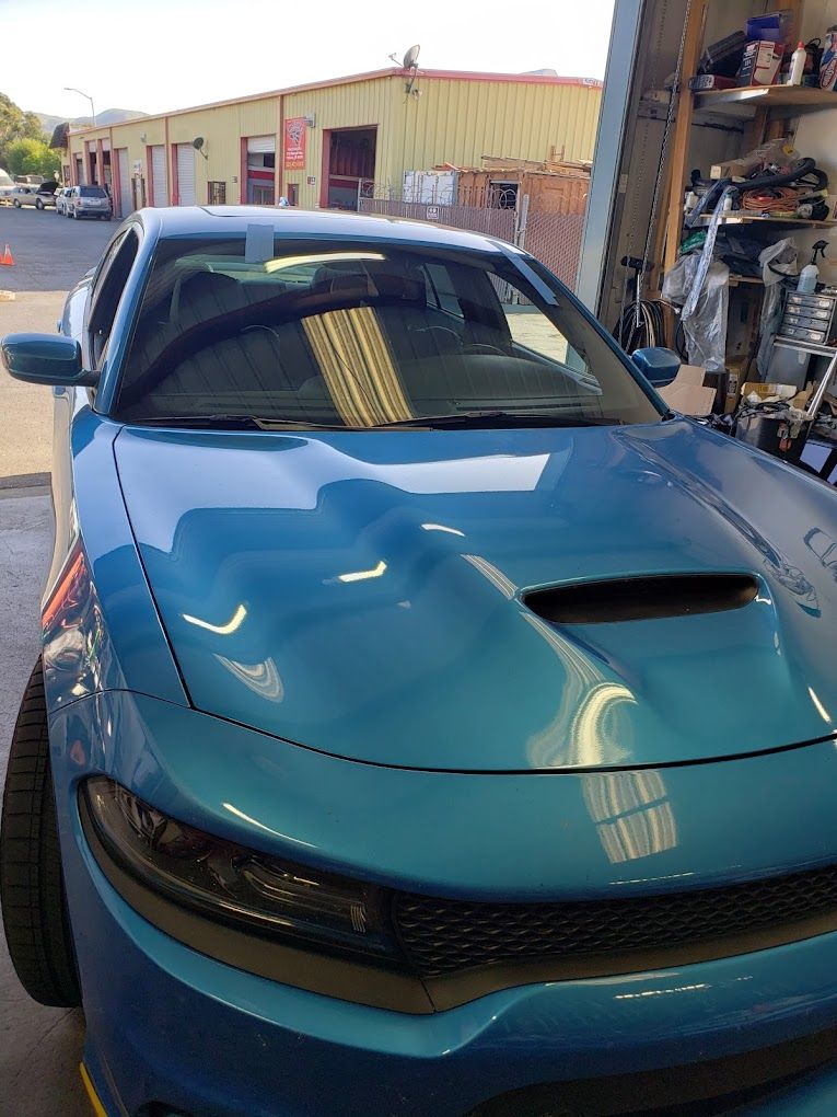 A blue dodge charger is parked in a garage.