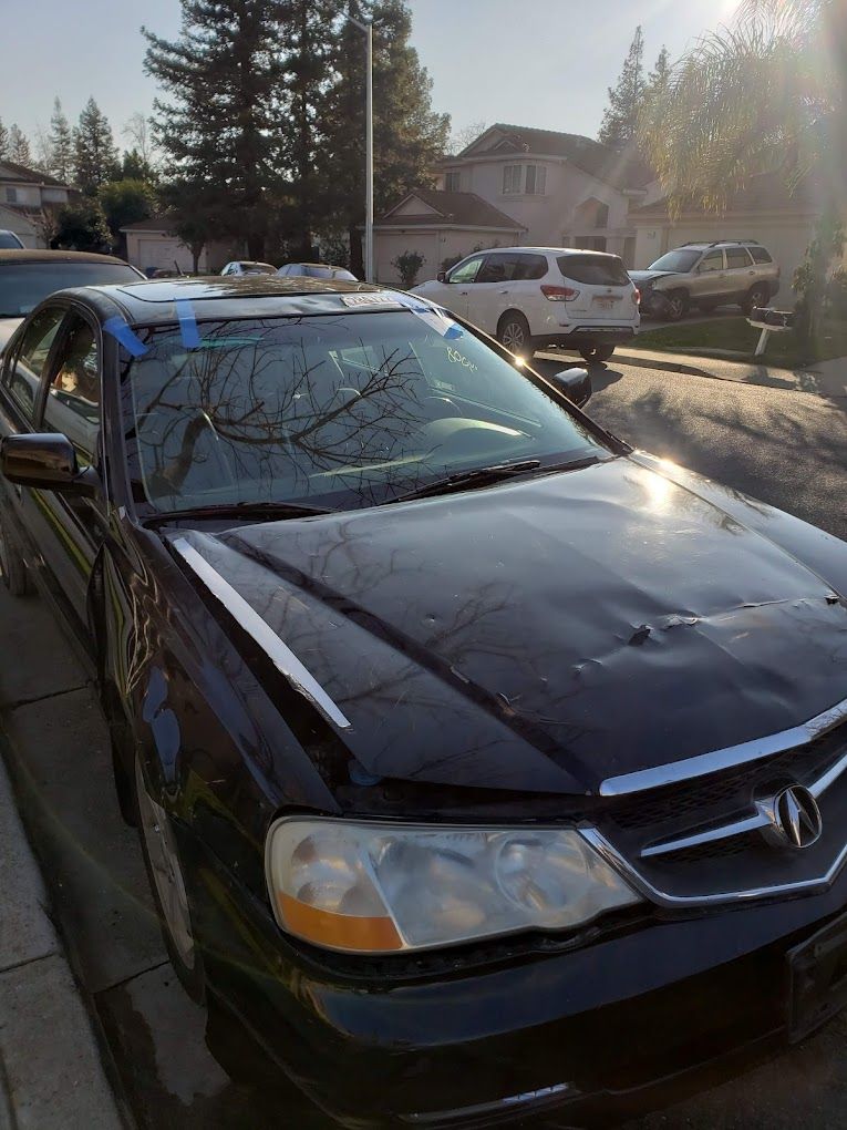A black car is parked on the side of the road.
