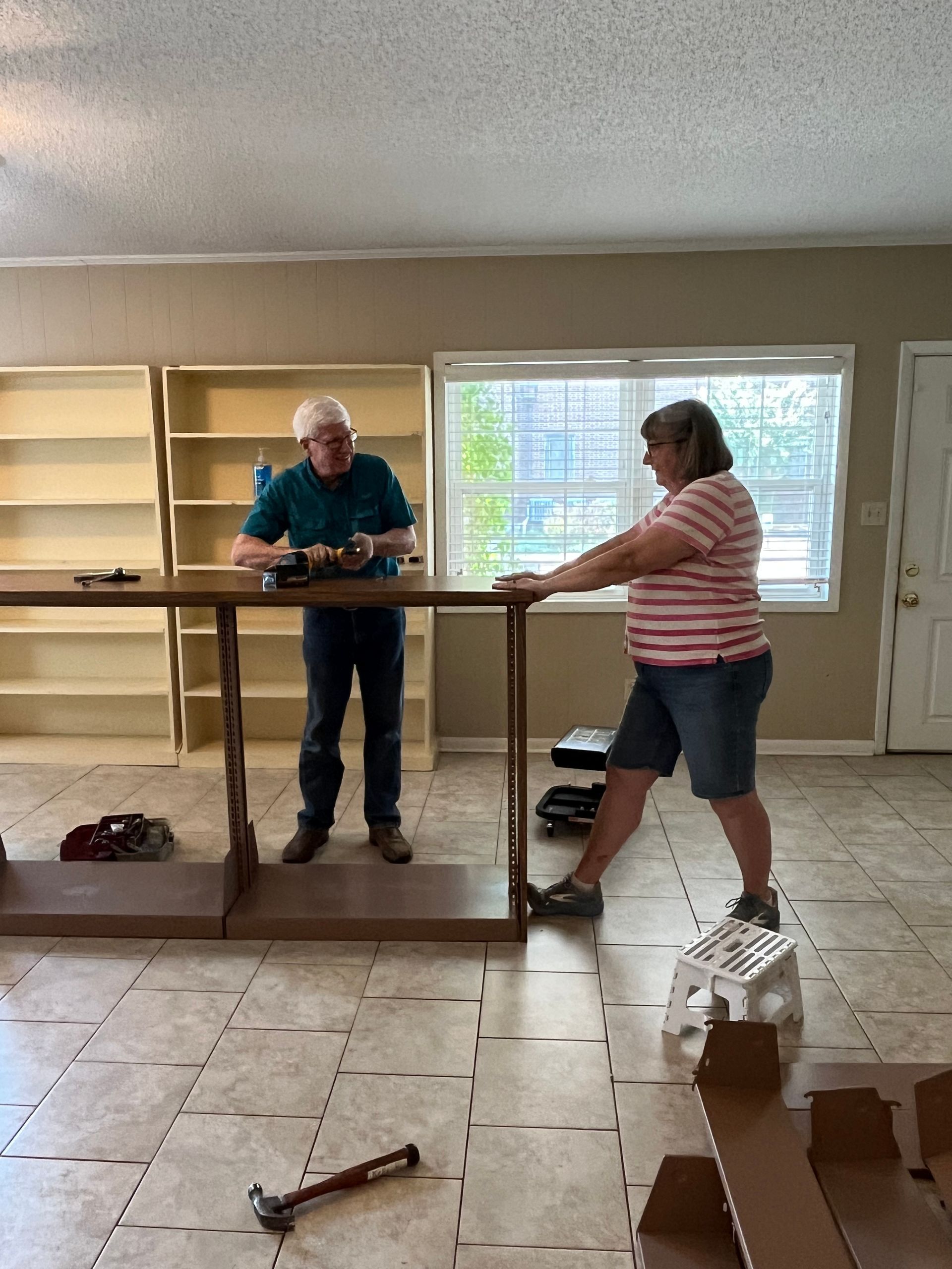 man and woman building shelves in new  GCHGS office