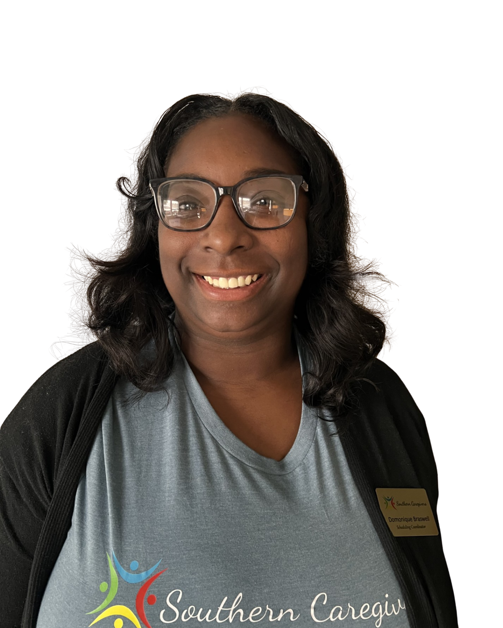 Smiling person with glasses wearing a gray Southern Caregivers shirt and black cardigan on a white background