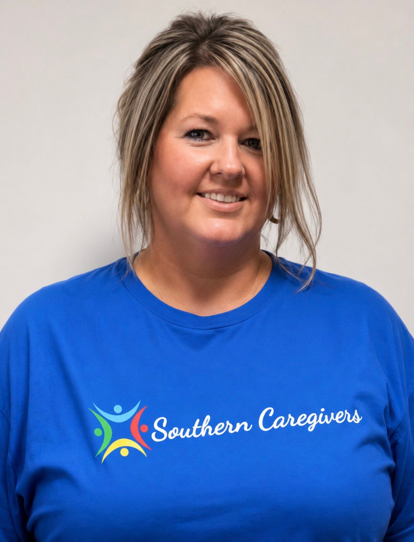 Woman in blue Southern Caravans T-shirt smiling against a light gray background