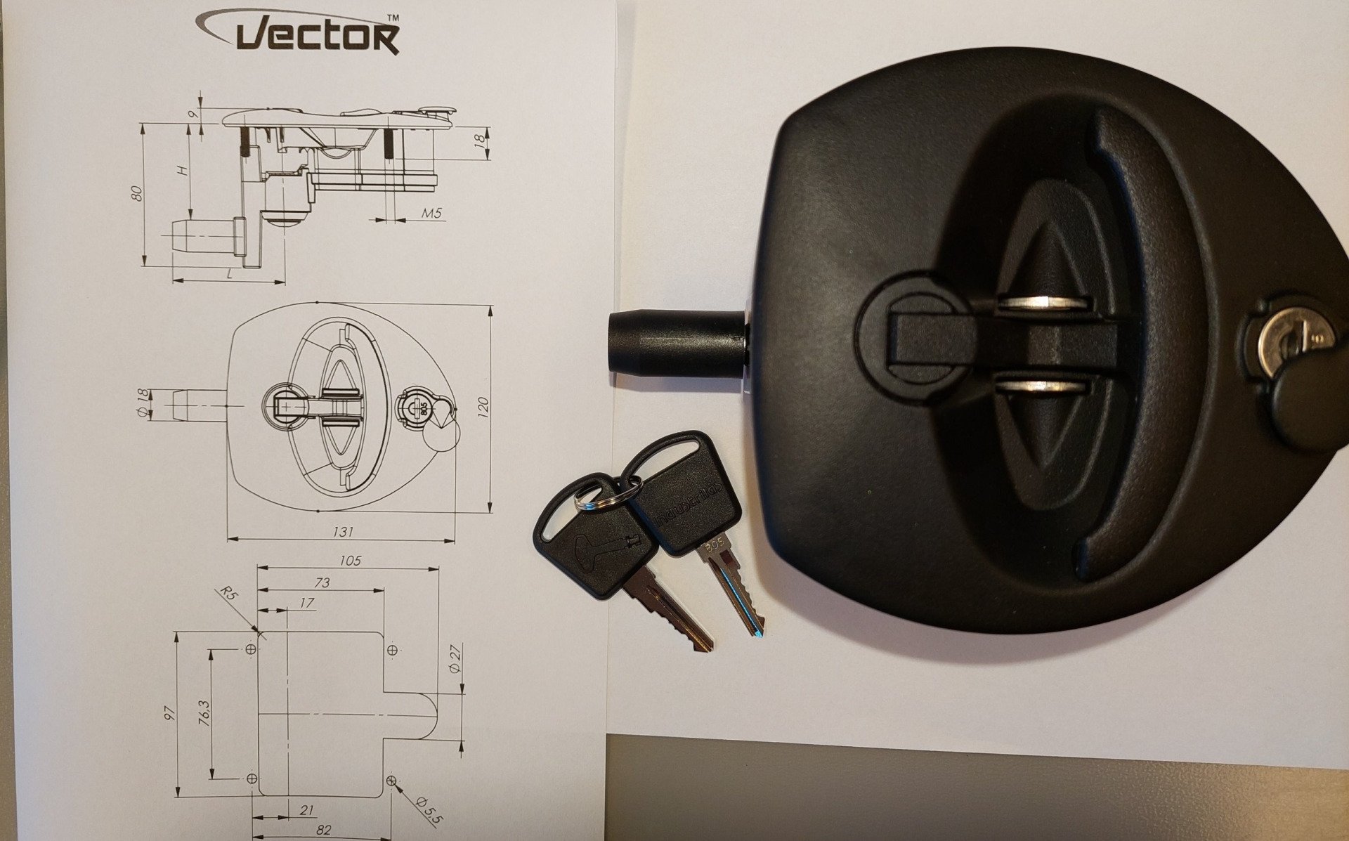 Ein Schlüsselpaar neben einem schwarzen Objekt mit der Aufschrift „Vektor“