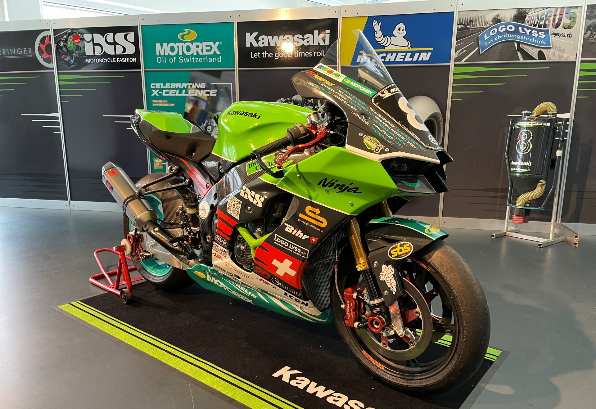 Ein grünes Kawasaki-Motorrad ist in einem Ausstellungsraum ausgestellt