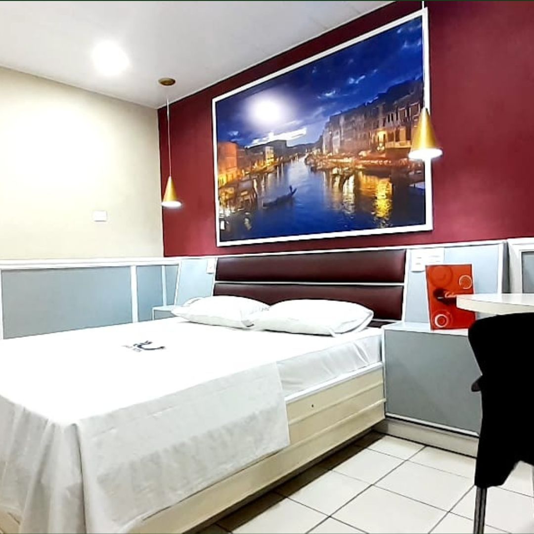 Um quarto de hotel com uma grande foto na parede acima da cama