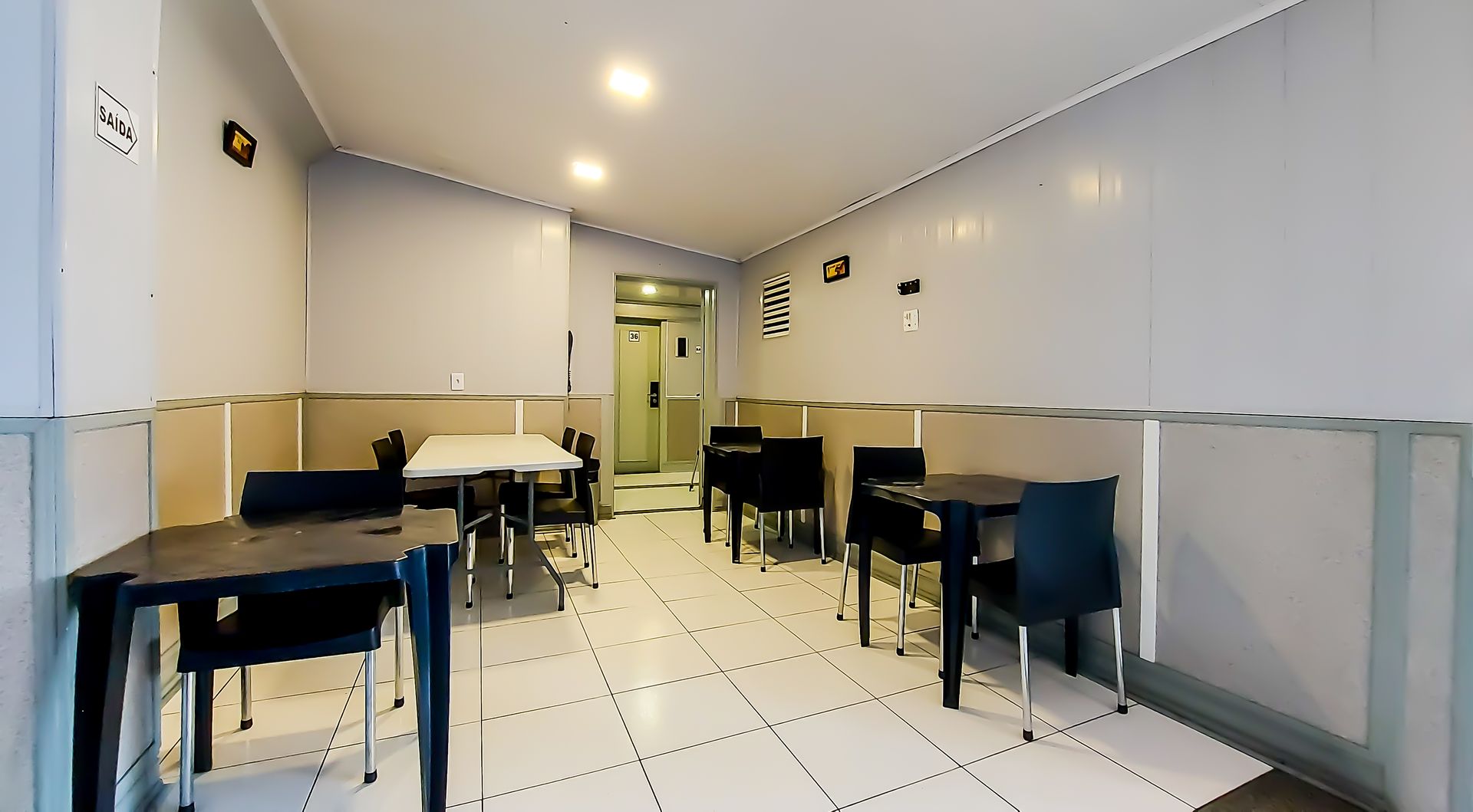 Uma sala com mesas e cadeiras