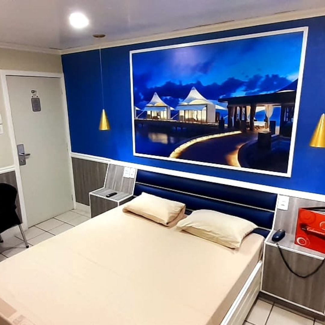 Um quarto de hotel com uma grande foto na parede acima da cama