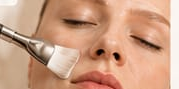 Trattamento viso spa con applicazione di crema bianca con un pennello sul viso rilassato.