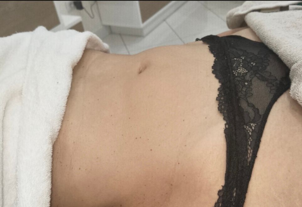 Primo piano di un torso nudo che indossa lingerie di pizzo nero da un lato