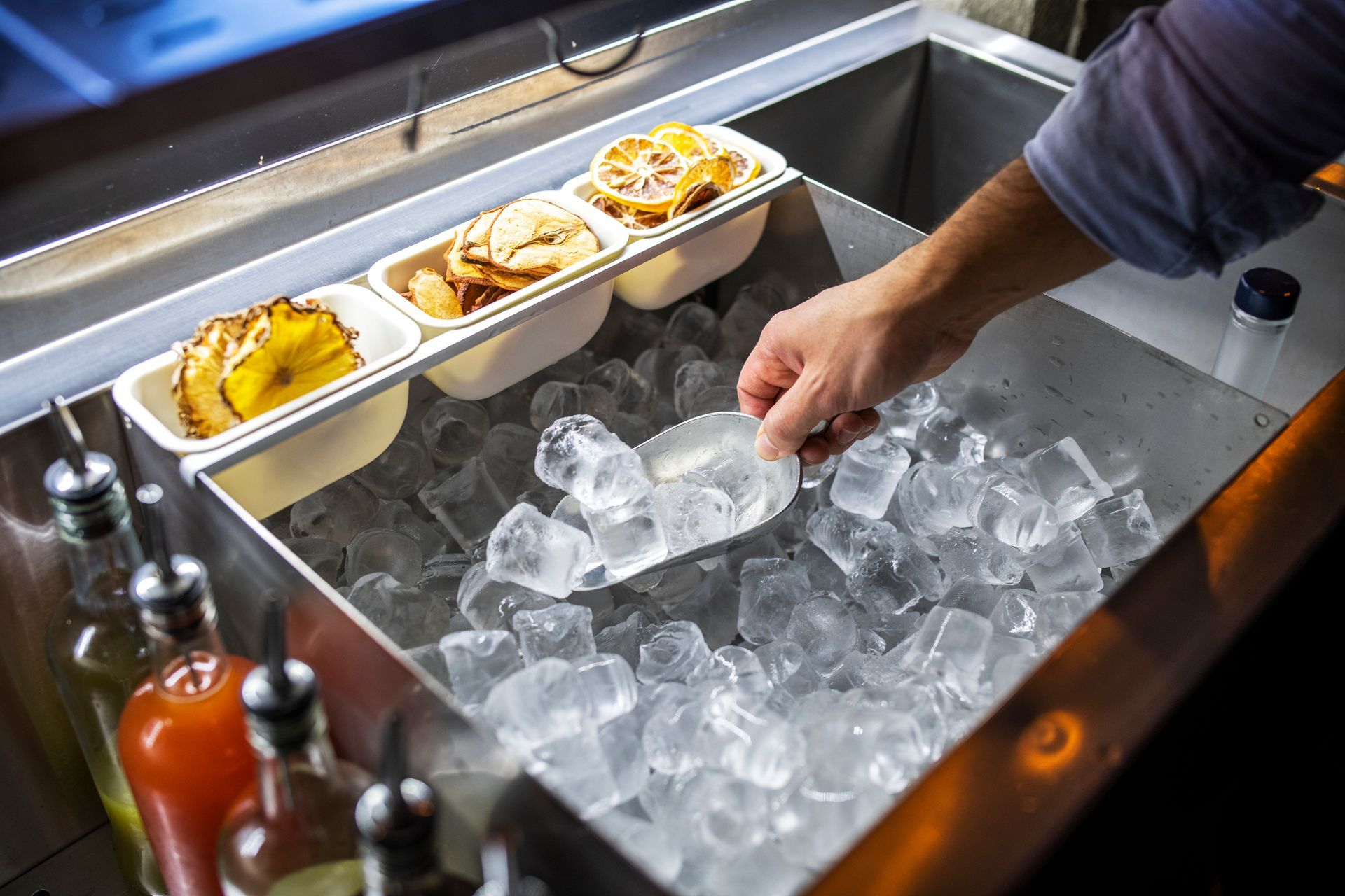 Bartender putting ice cubes in a glass. Bartender putting ice cubes in a glass.