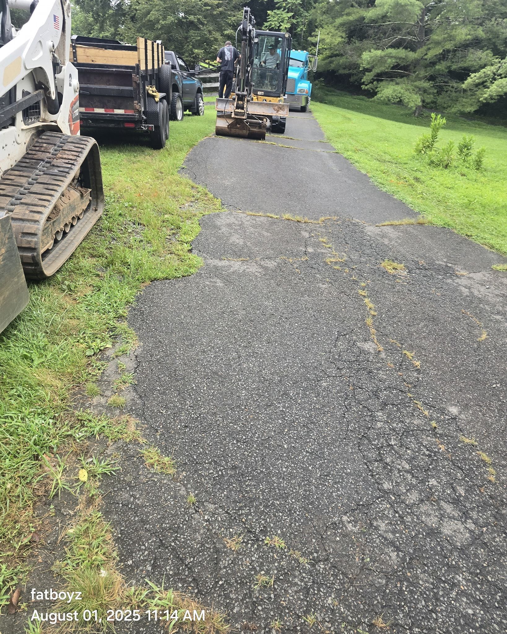 Freshly paved gravel path with construction equipment parked on both sides in a green area