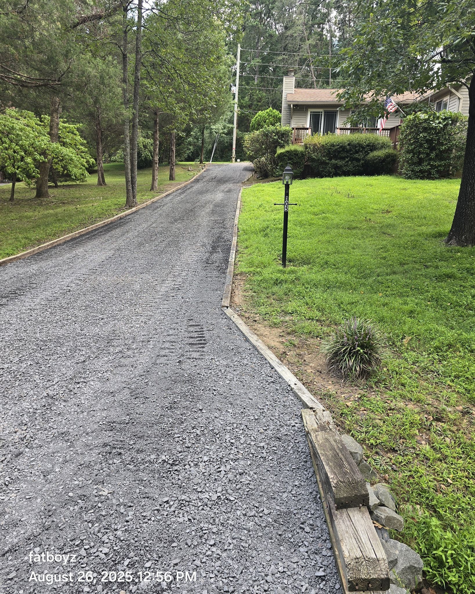 Gravel path through a green garden leading to a small house in the distance