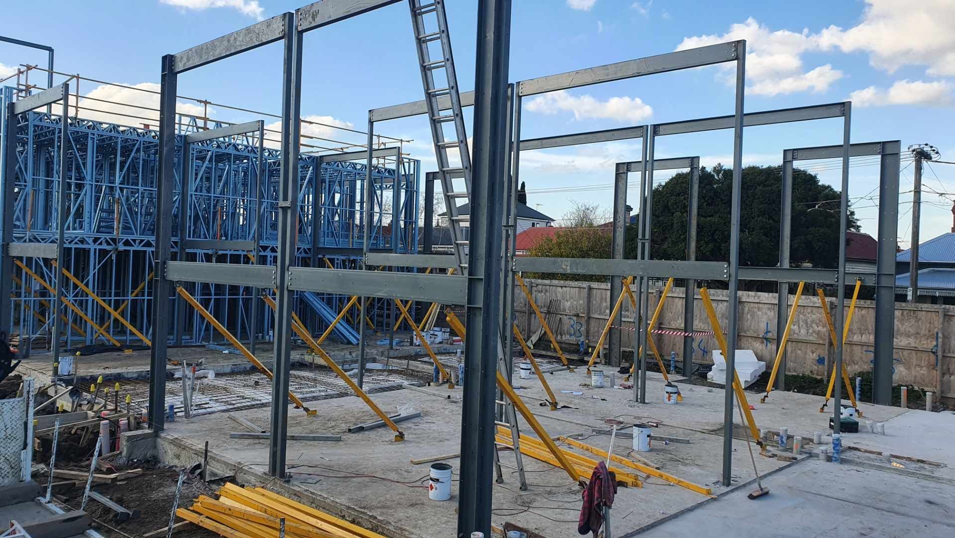 A large metal structure is being built on a construction site.