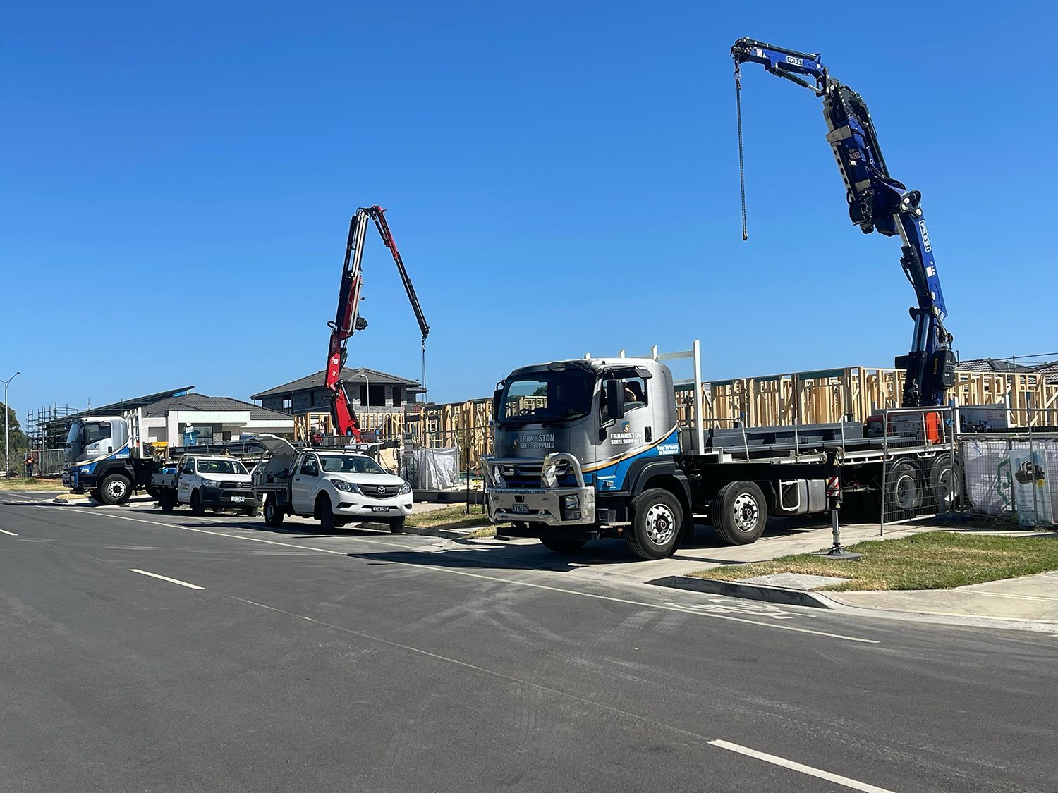 A truck with a crane on top of it is parked on the side of the road.