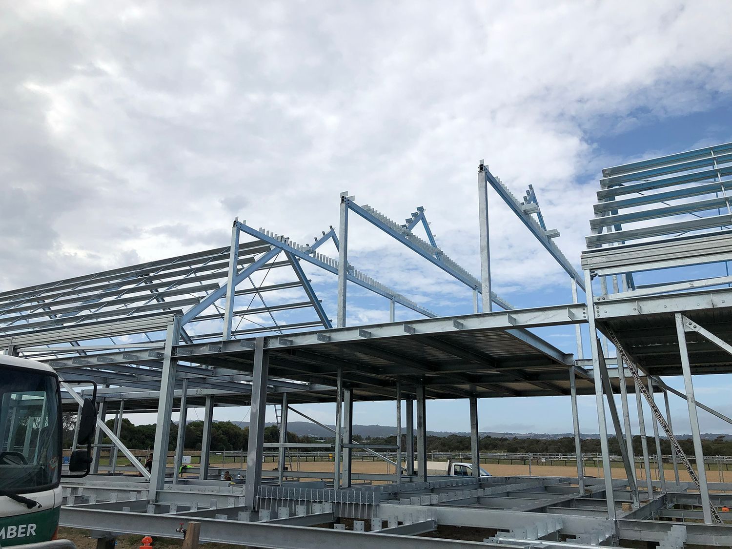 A large metal structure is being built in a field.