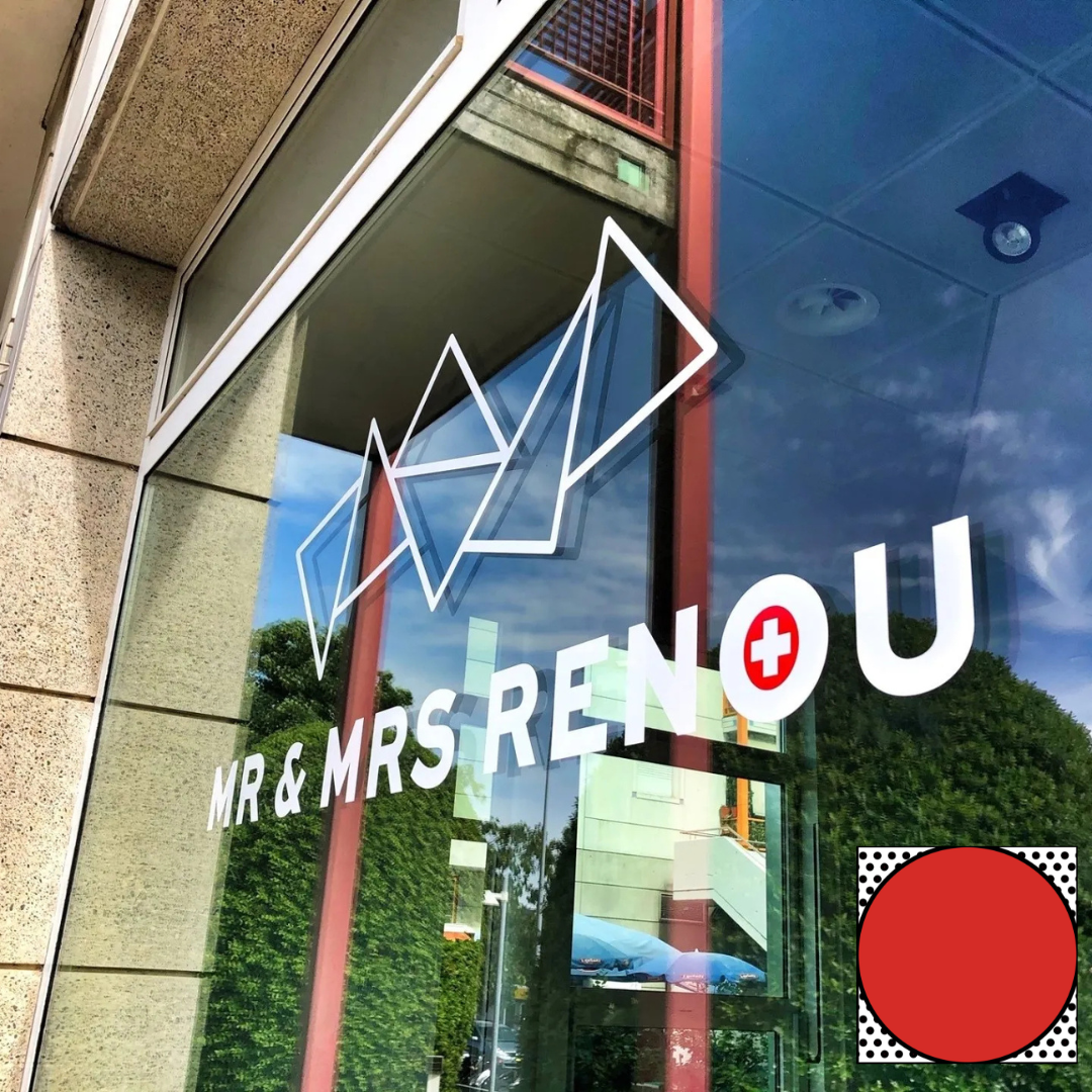 Vitrine en verre pour « MR & MRS RENOU » avec un logo géométrique et une croix rouge.