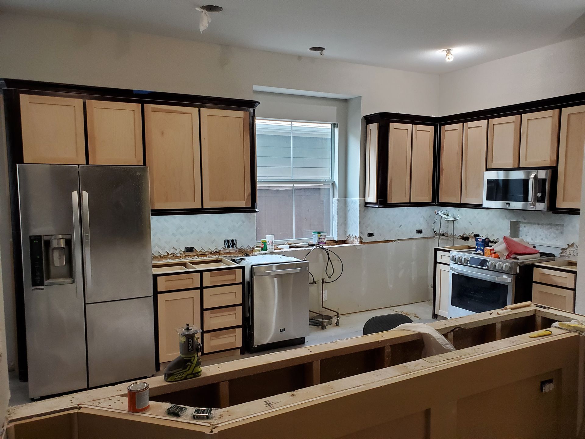 Kitchen undergoing renovation with new cabinets, appliances, and island. North Texas