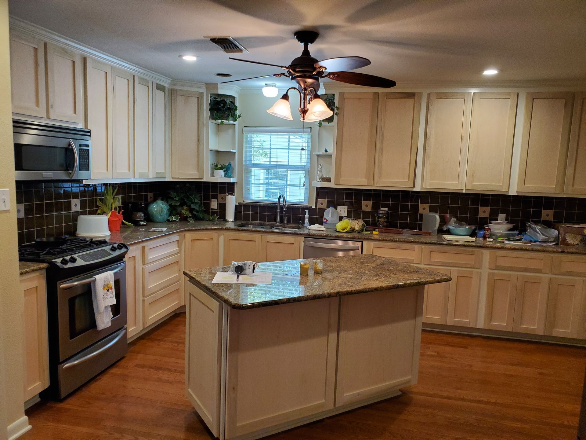 Kitchen with light-colored cabinets, granite countertops, stainless steel appliances, and a central island.