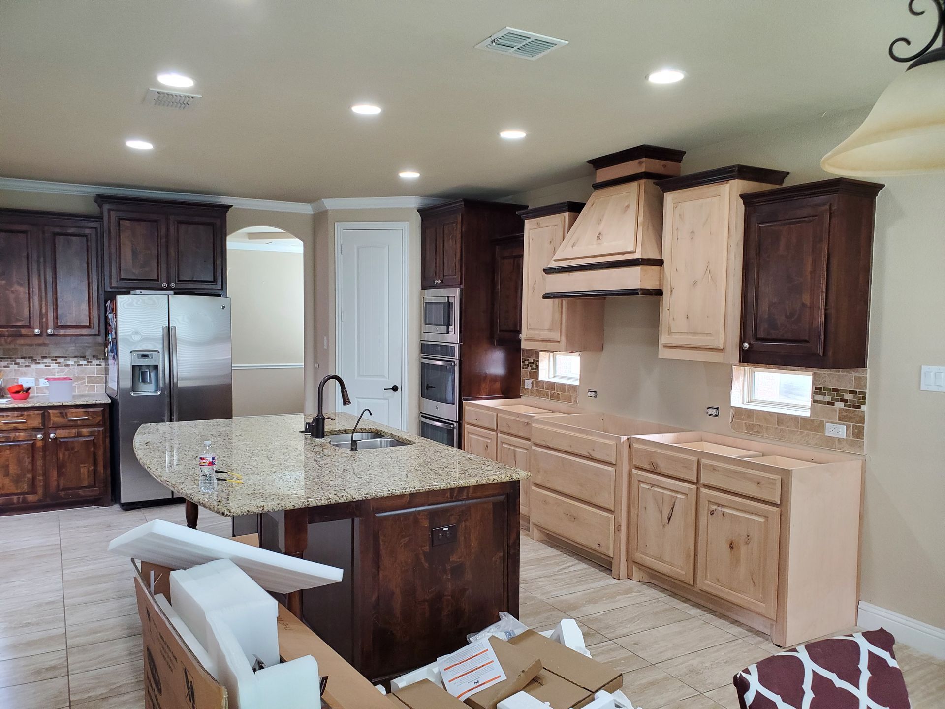 Kitchen with wood cabinets, island, stainless steel appliances, and granite countertops.