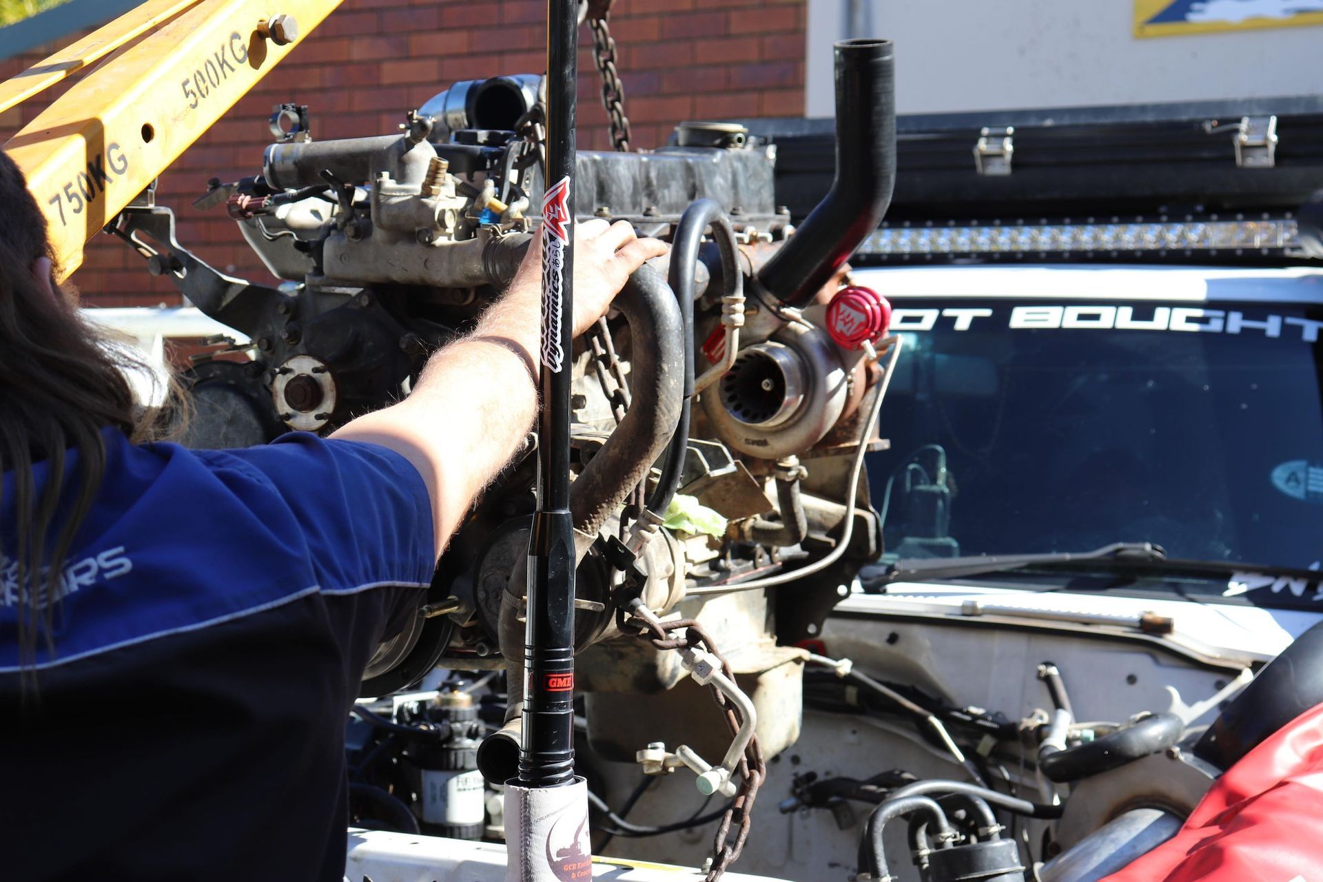 Engine Lifted By Crane Into White 4x4 Mechanic Guiding — Ballina Car Centre in Ballina, NSW
