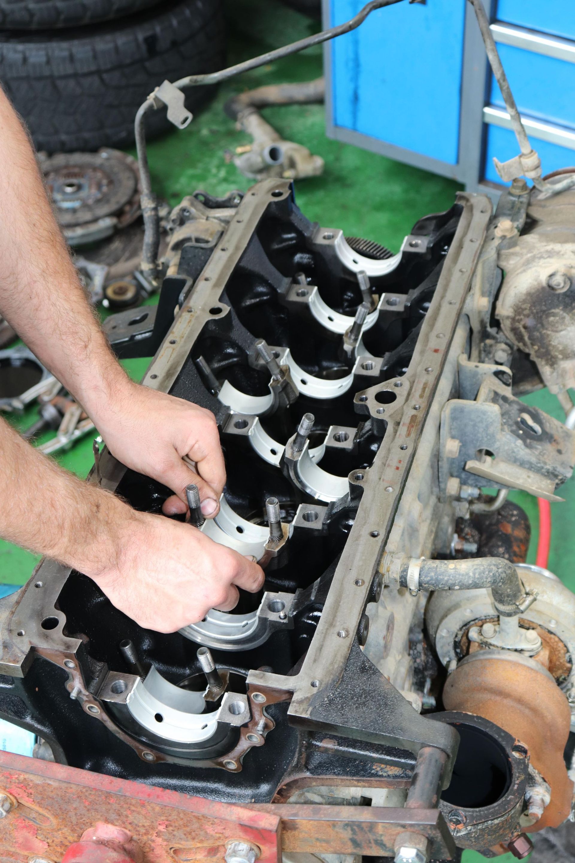 Hands Installing Engine Bearings In Truck Engine Block — Ballina Car Centre in Ballina, NSW