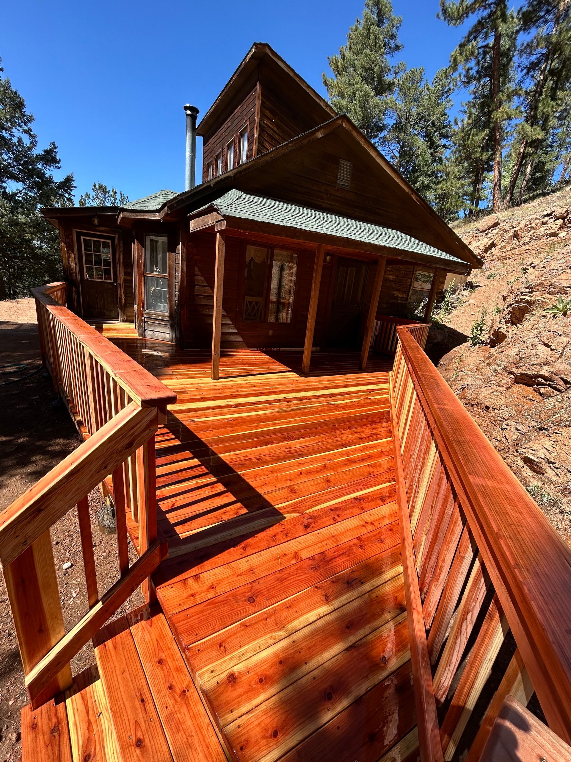 A wooden deck with stairs leading up to a house.