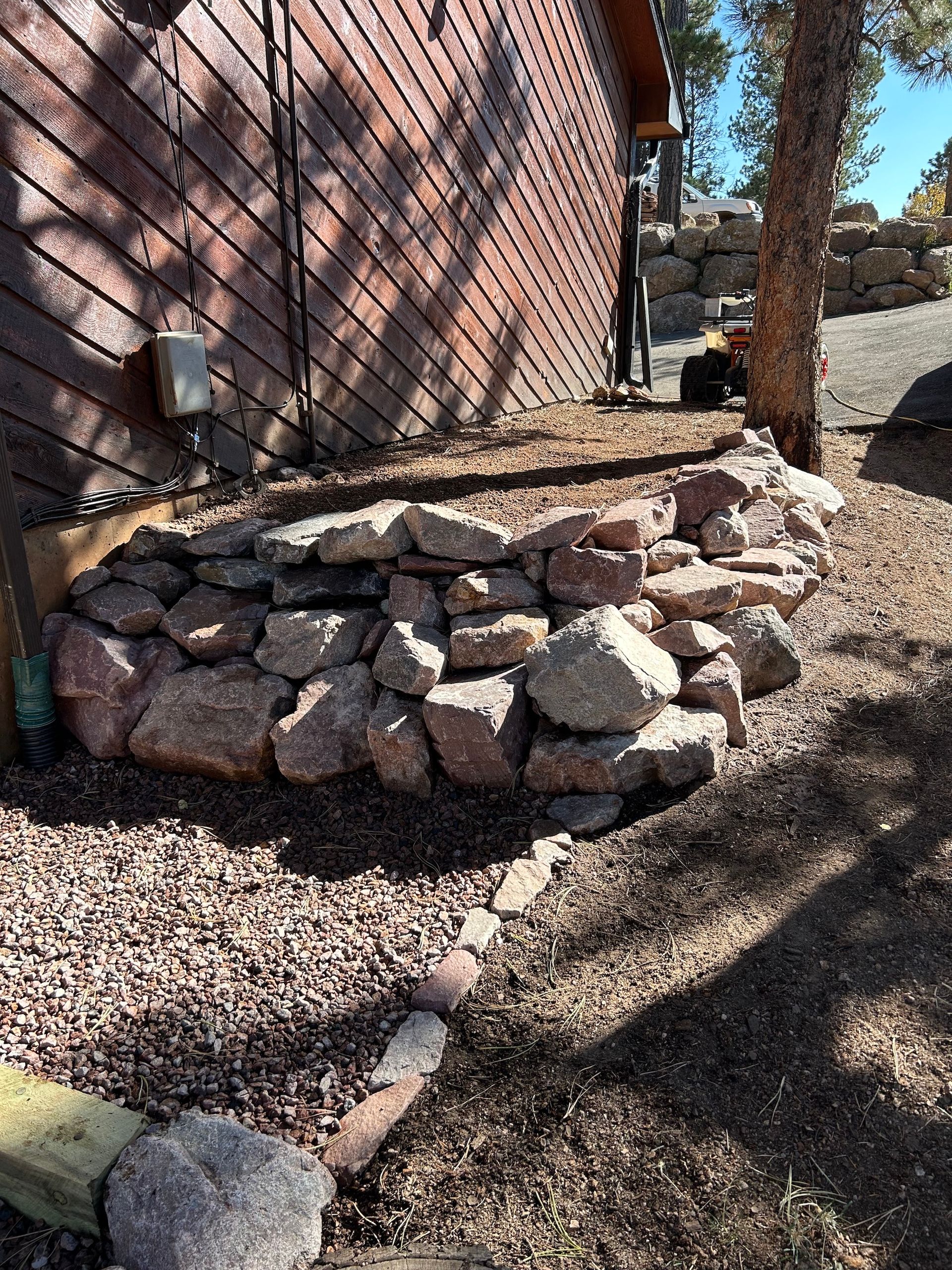 A pile of rocks is sitting in front of a brick building.