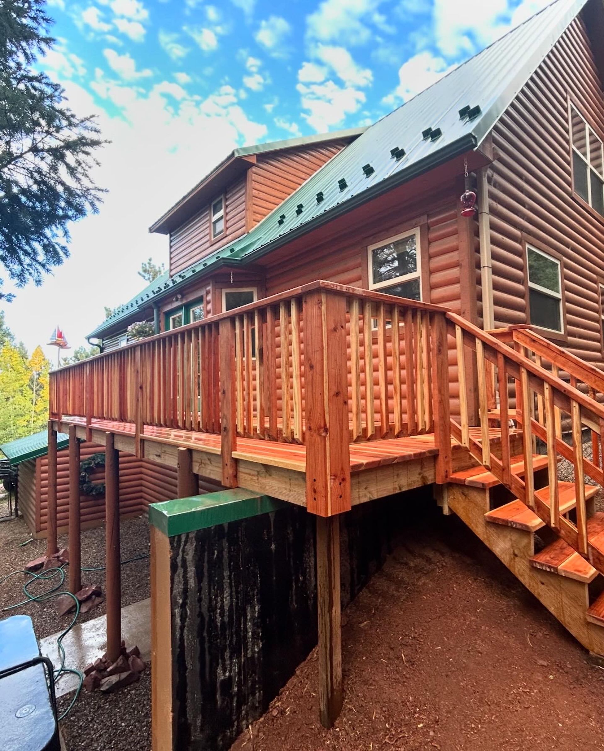 A log cabin with a wooden deck and stairs