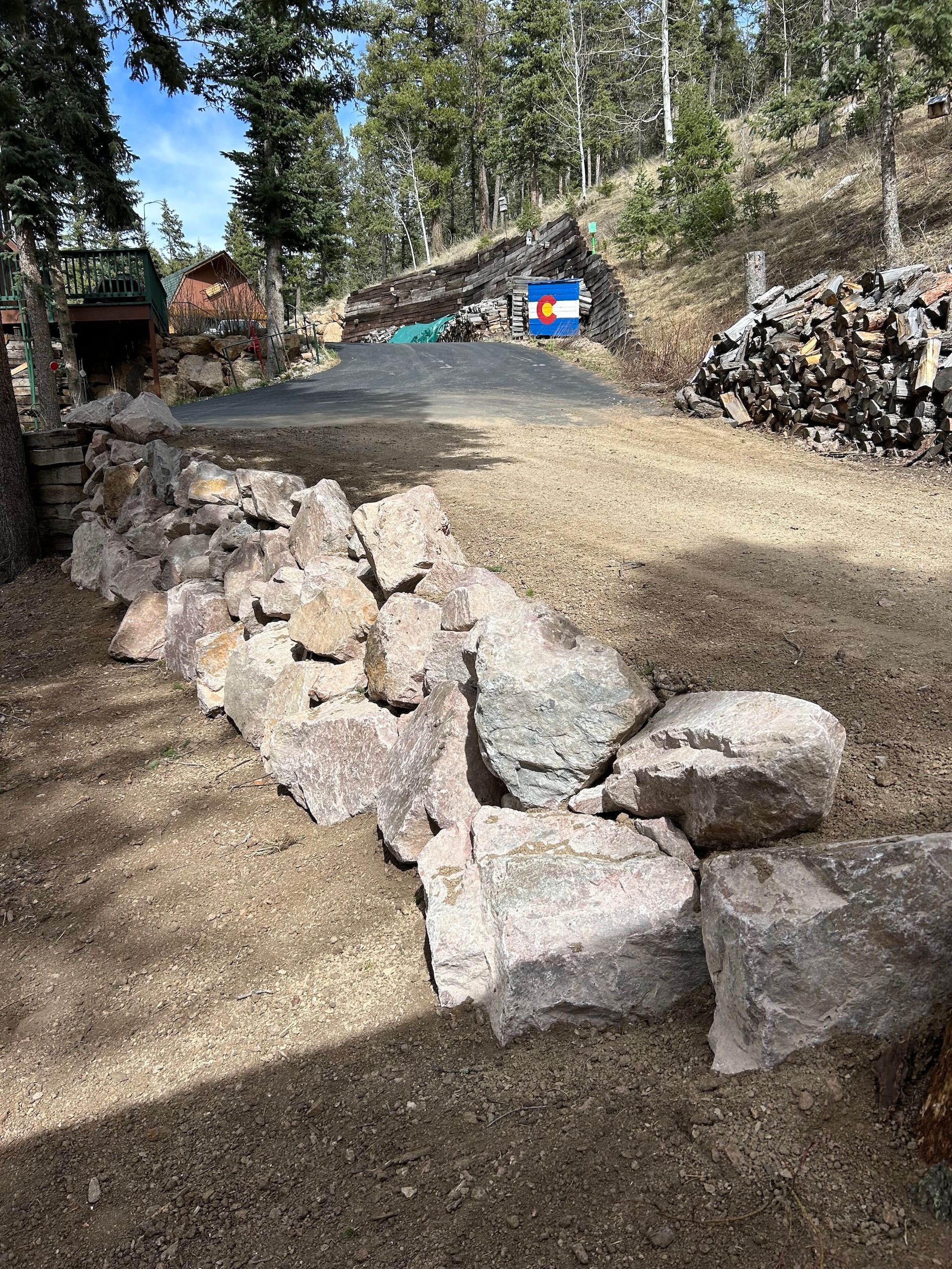 A pile of rocks sitting on top of a dirt field next to a road.