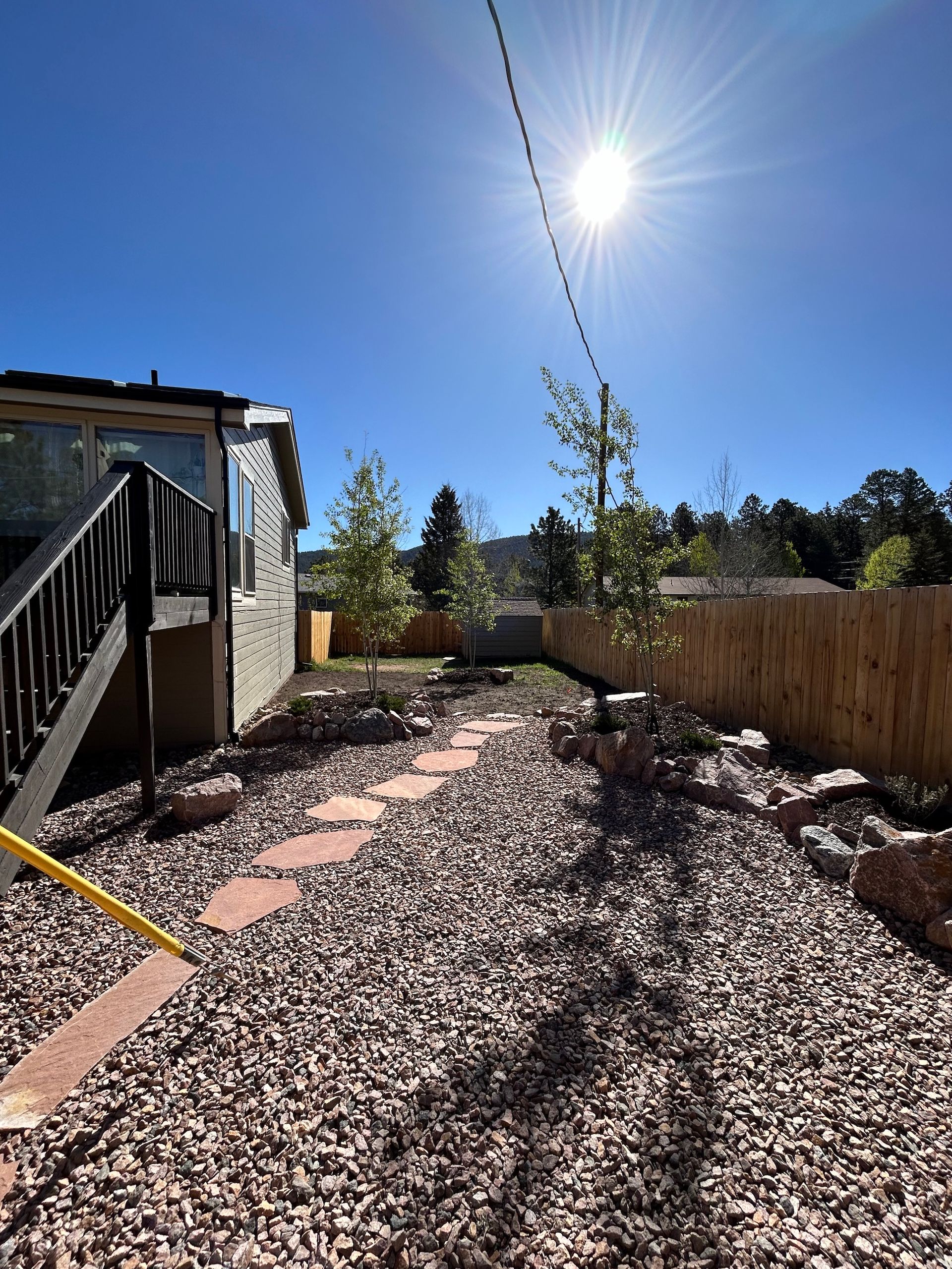 The sun is shining brightly in the backyard of a house