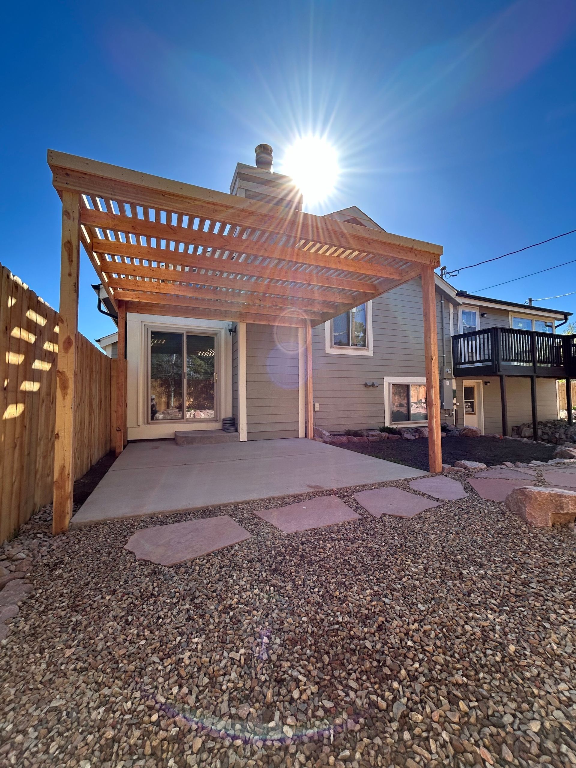 A house with a wooden pergola in the backyard